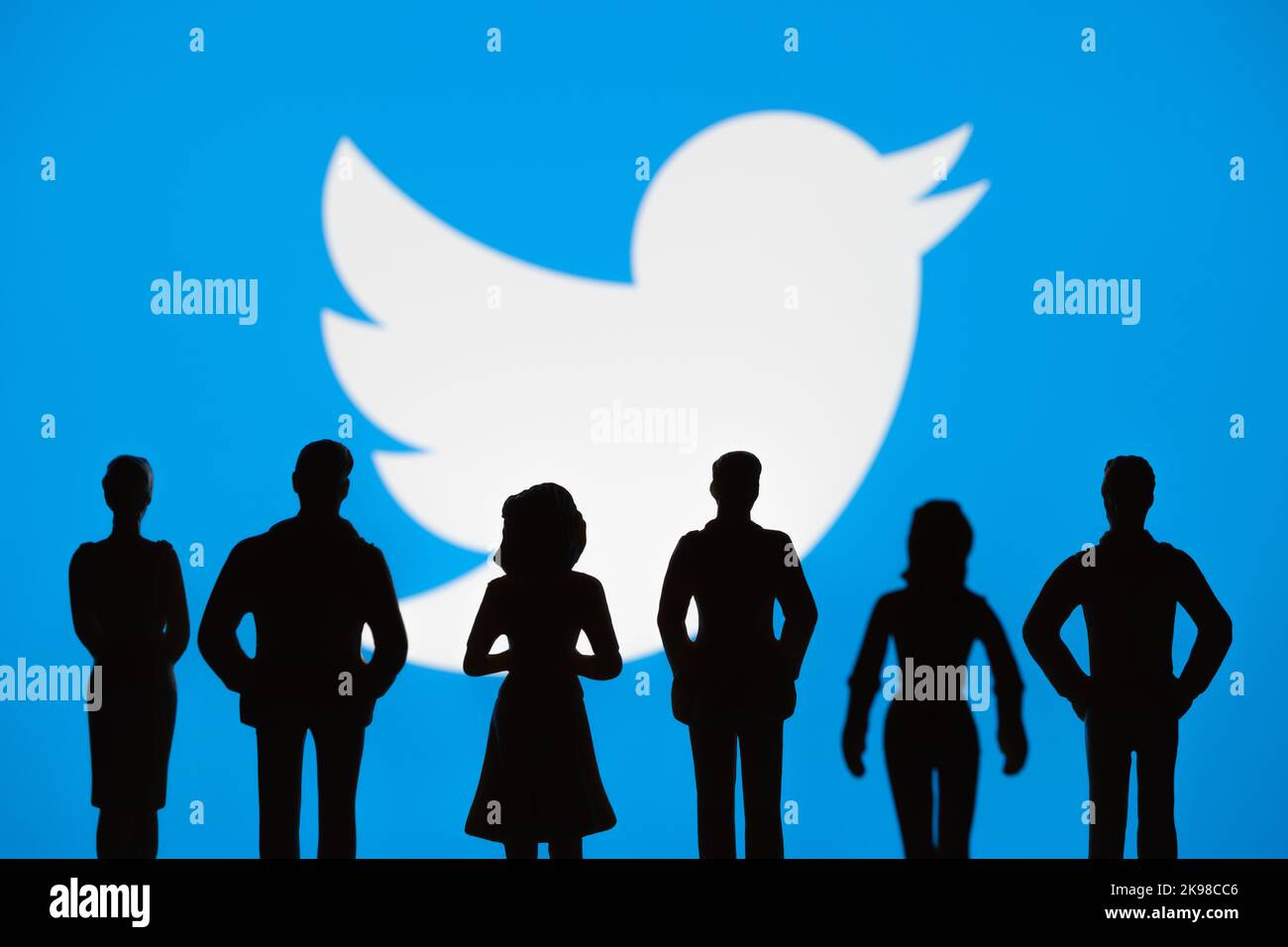 People figurine silhouettes are seen in front of blurred Twitter logo on display. Concept. Stafford, United Kingdom, October 26, 2022. Stock Photo