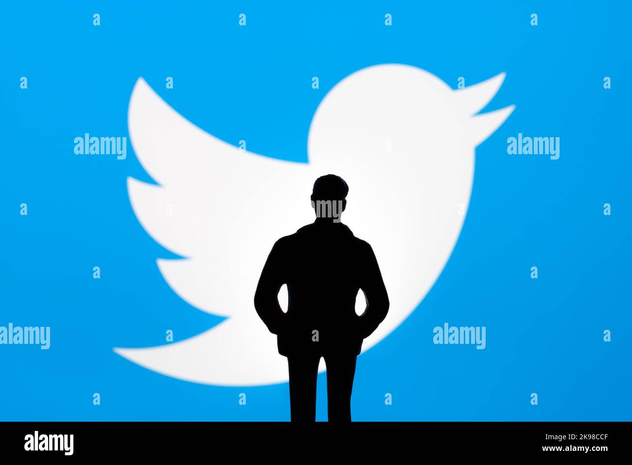 Twitter and Elon Musk deal concept. Figurine silhouette is seen in front of blurred Twitter logo on display. Stafford, United Kingdom, October 26, 202 Stock Photo