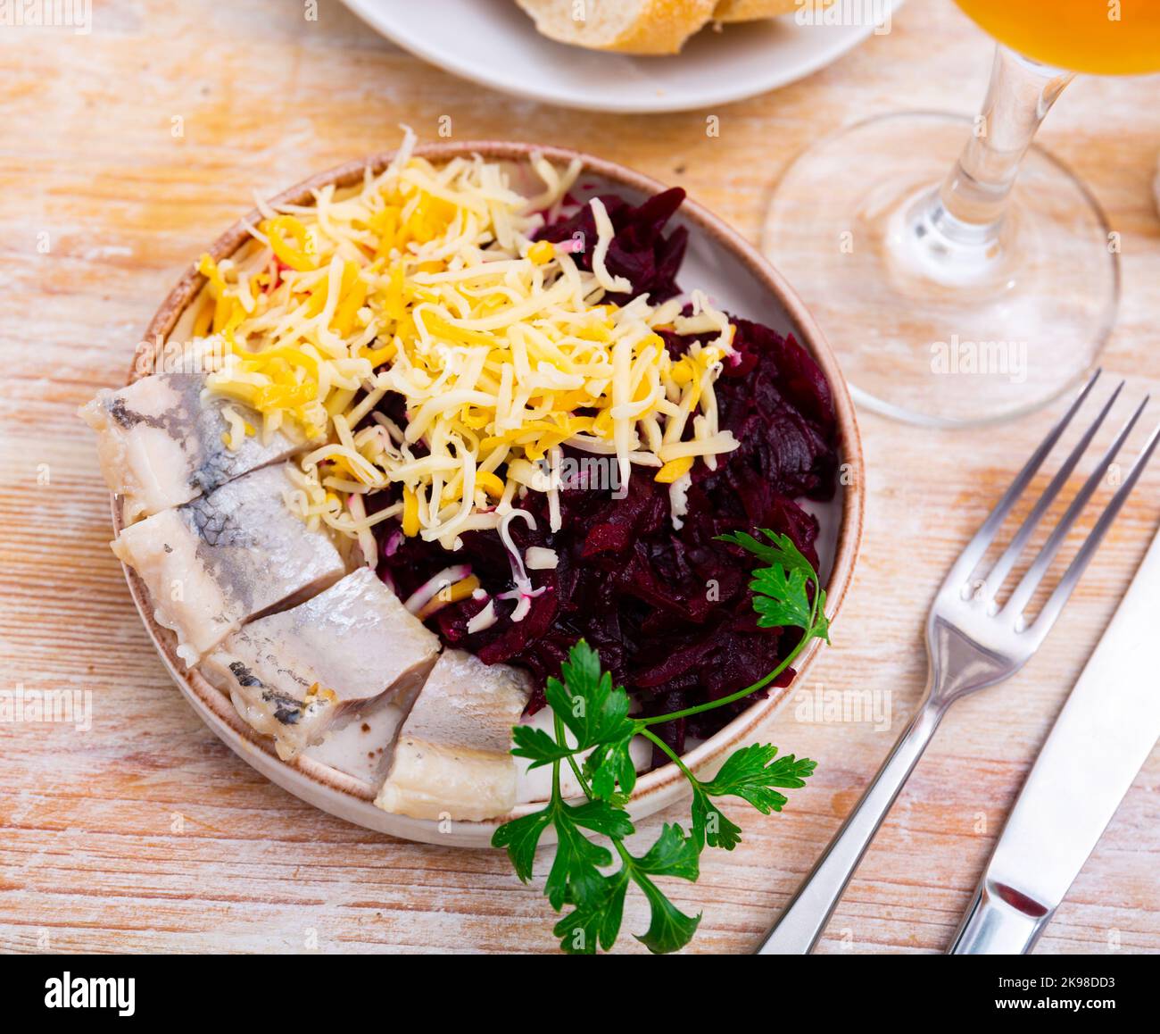 Sliced herring with grated beetroot and cheese served on table Stock Photo