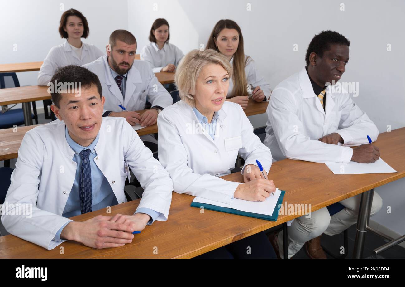People in white coats in boardroom Stock Photo