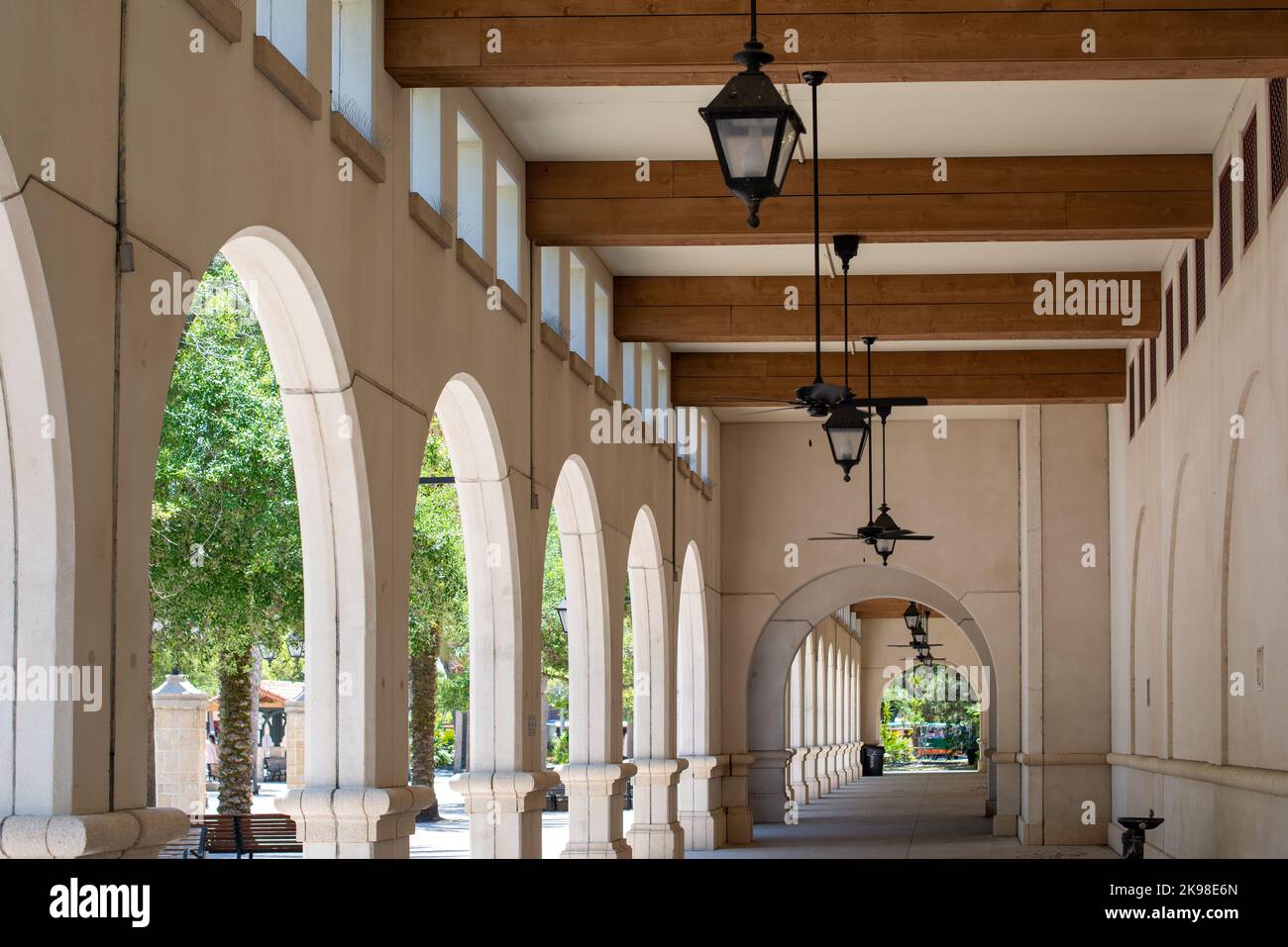 Lightner Museum, the historical white cement Spanish style colonnade has hanging black light fixtures and wooden beams with small windows over the Stock Photo