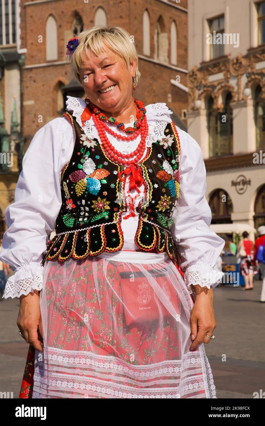 Smiling souvenir vendor wearing a traditional dress costume in the Main Market Square, Cracow, Poland Stock Photo