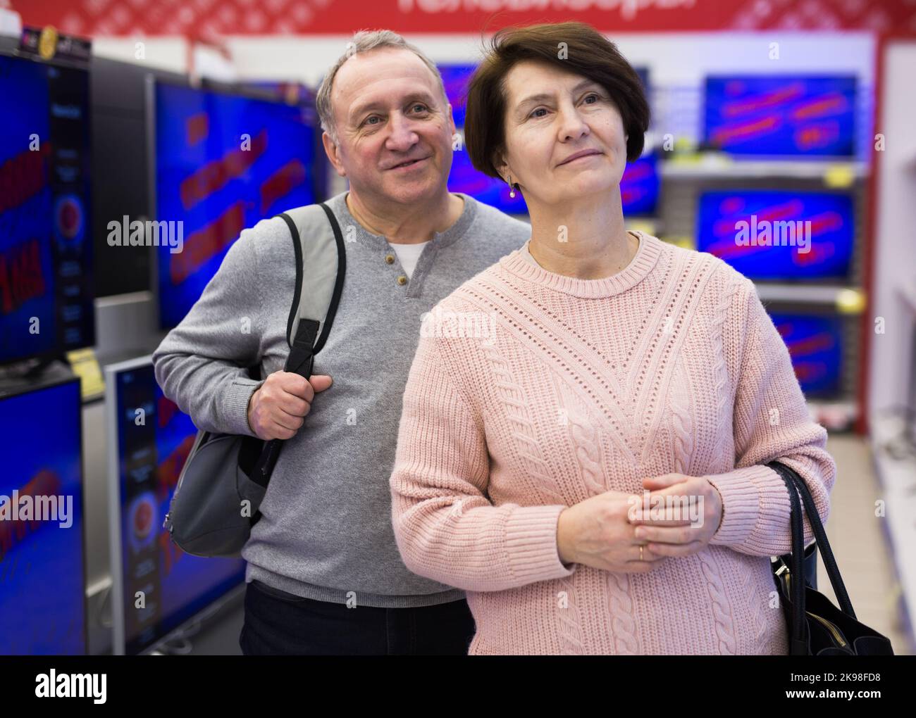 Senior couple picking new TV in tech store Stock Photo