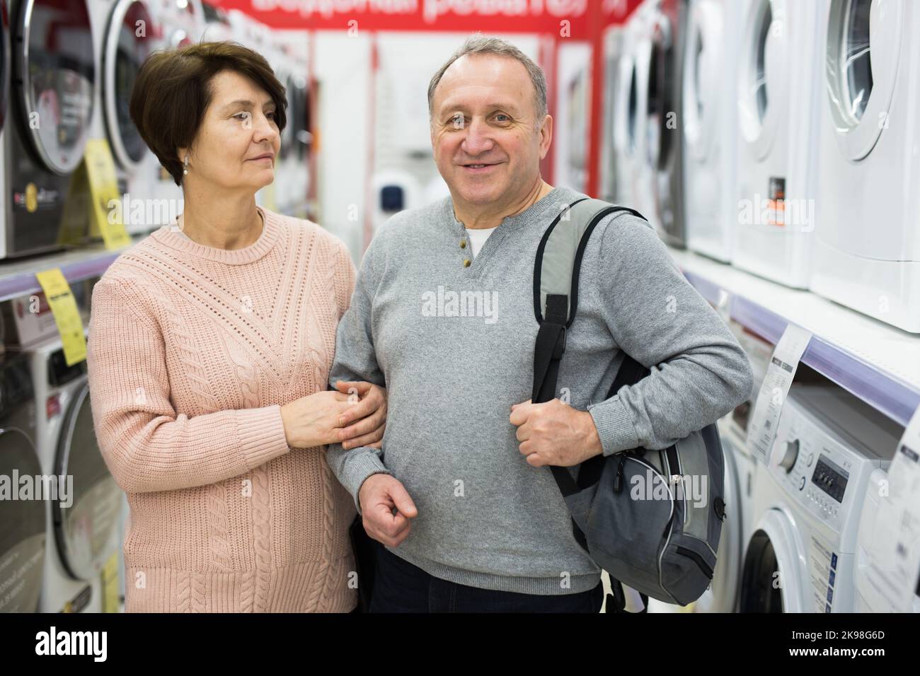 Senior couple standing in washing machines department of appliance store Stock Photo