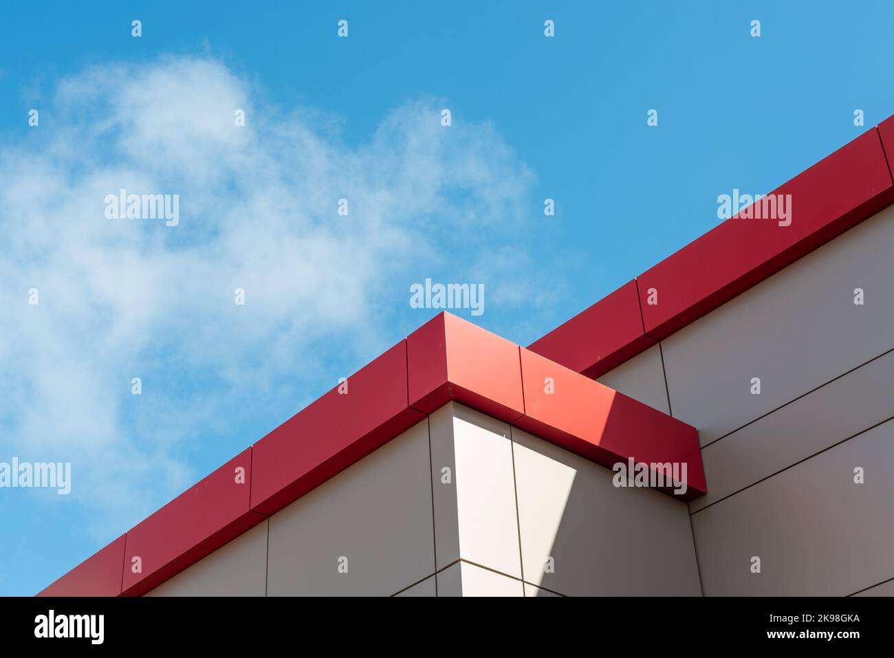 The exterior wall of a contemporary commercial style building with aluminum metal composite panels and glass windows. The futuristic building has engi Stock Photo