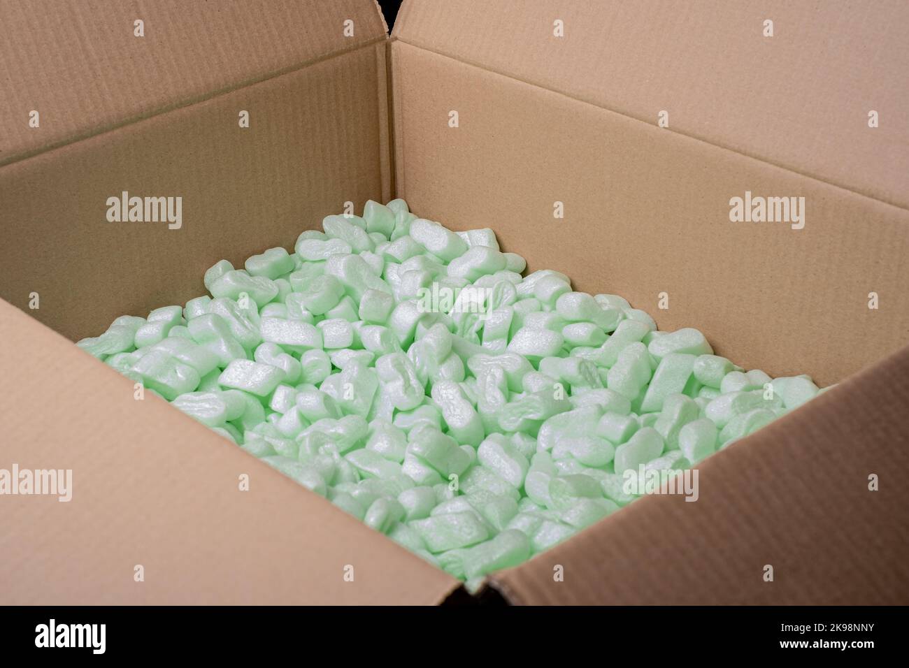 cardboard box filled with green foam protective granules. Online