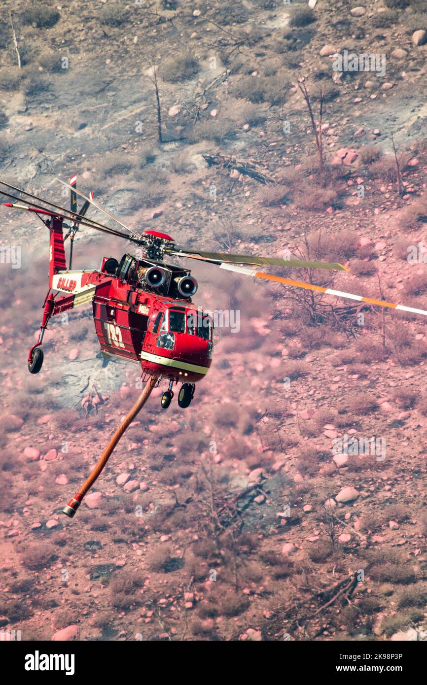 Firefighting helicopter over  brush wildfire in California Stock Photo