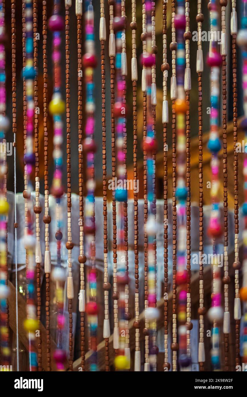 Fragment of a curtain of a plastic beads. Old wooden curtain of beads in the kitchen. Nobody, blurred, selective focus Stock Photo