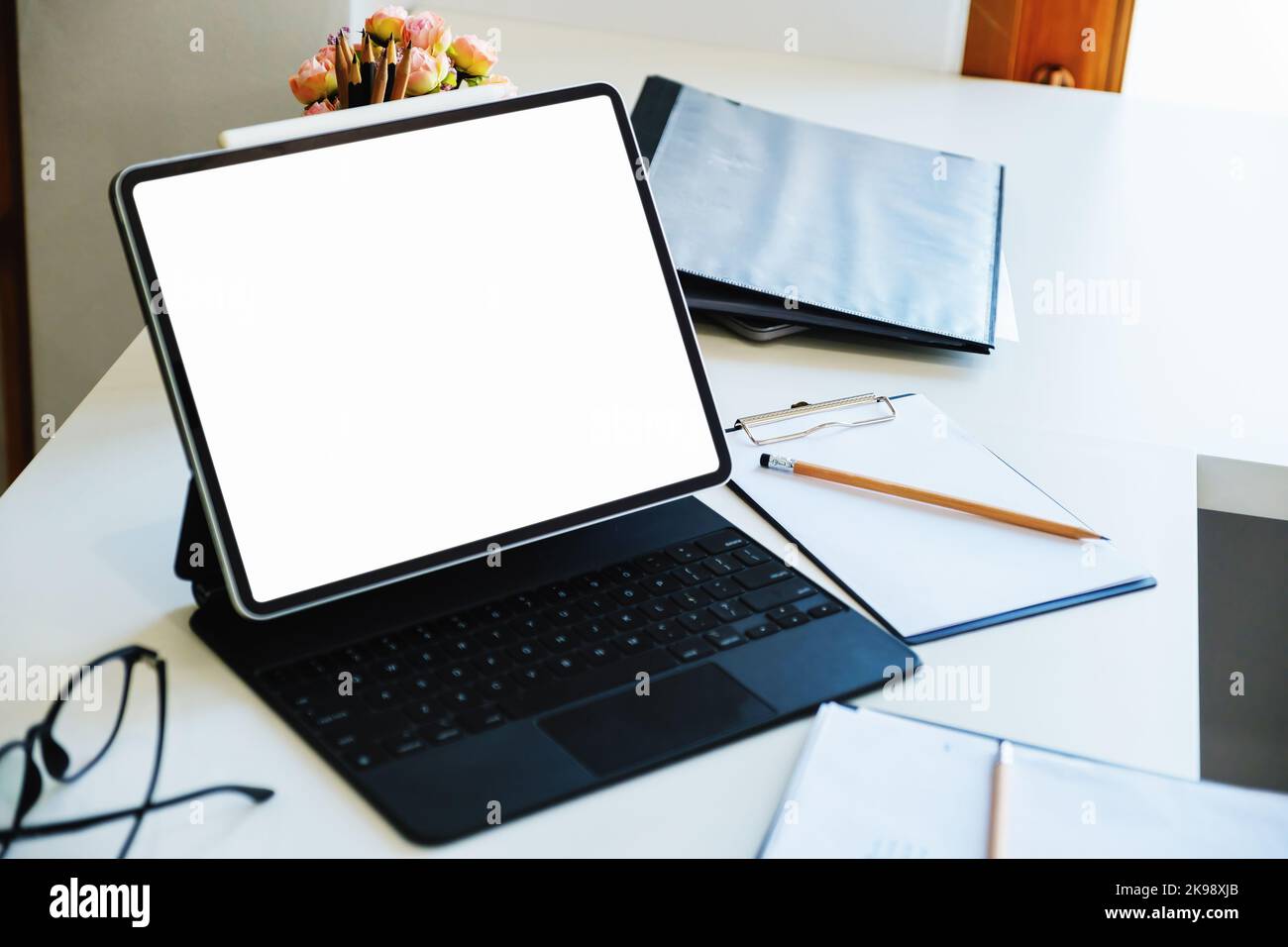 A white screen tablet computer placed on the desk at work. Can put text ...
