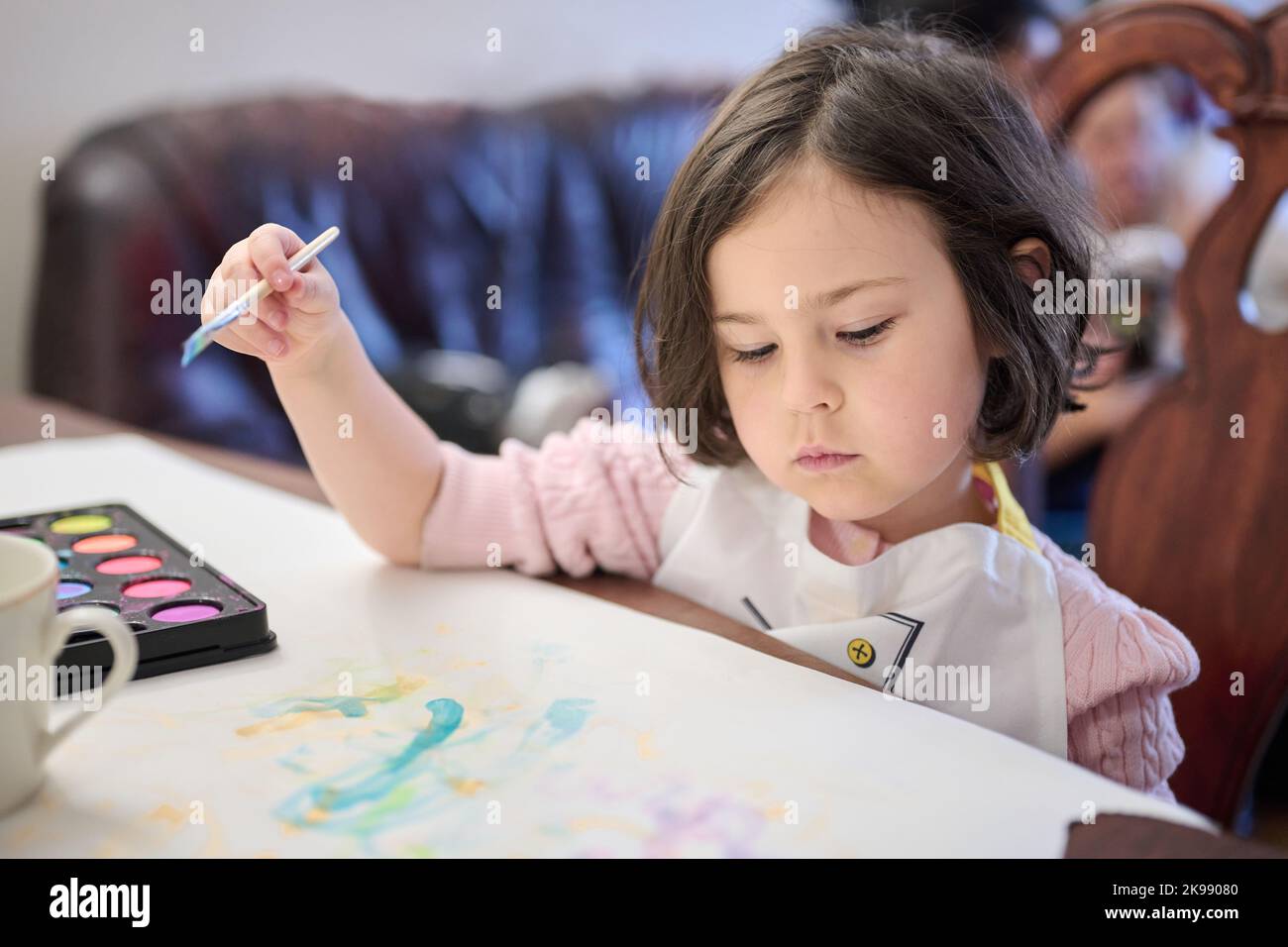 Concentrated girl is painting with watercolors Stock Photo - Alamy