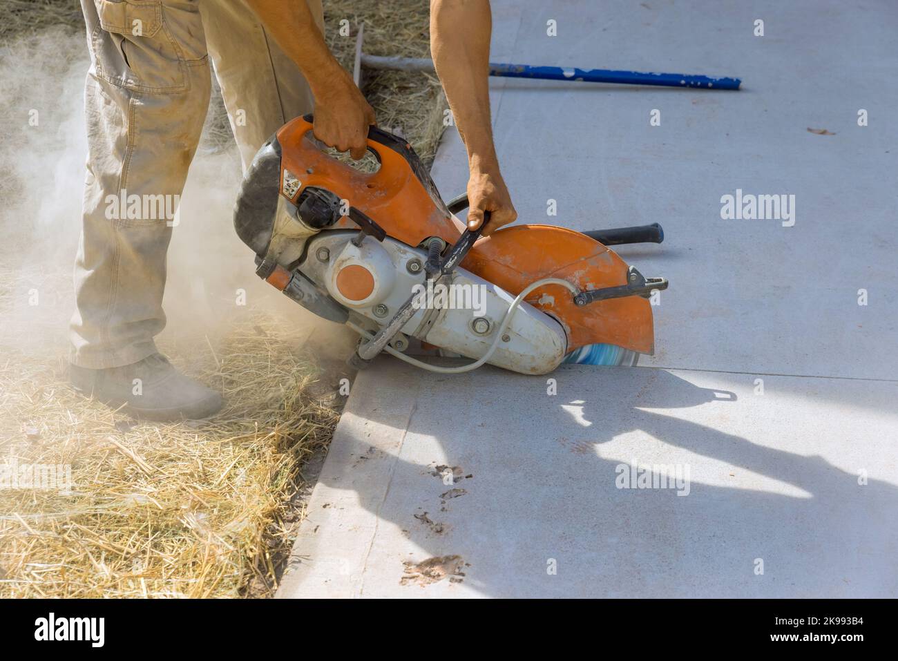 Cutting concrete sidewalk with diamond blade saw in reconctruction works Stock Photo