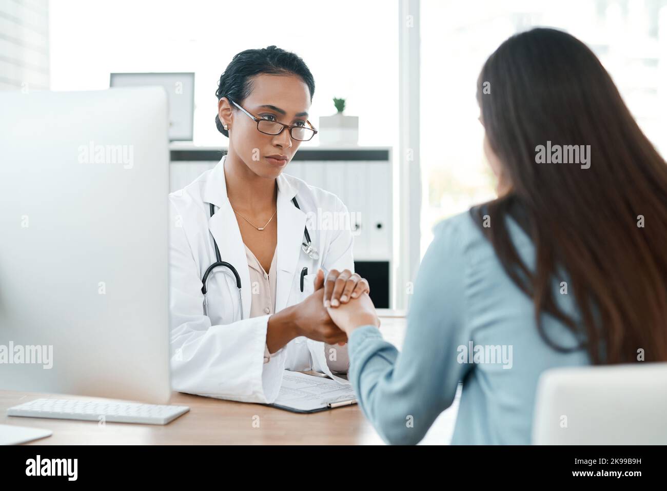 Im glad that you told me. a female doctor comforting her patient Stock