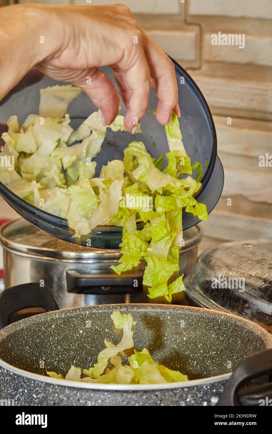 Chef is throwing lettuce in pot on gas stove Stock Photo Alamy
