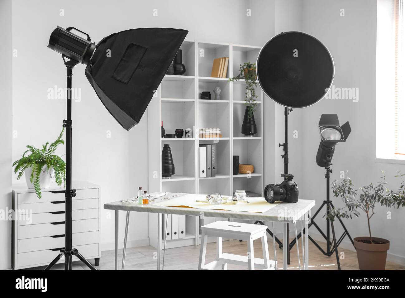 Interior of light office with photographer's workplace, shelving unit ...