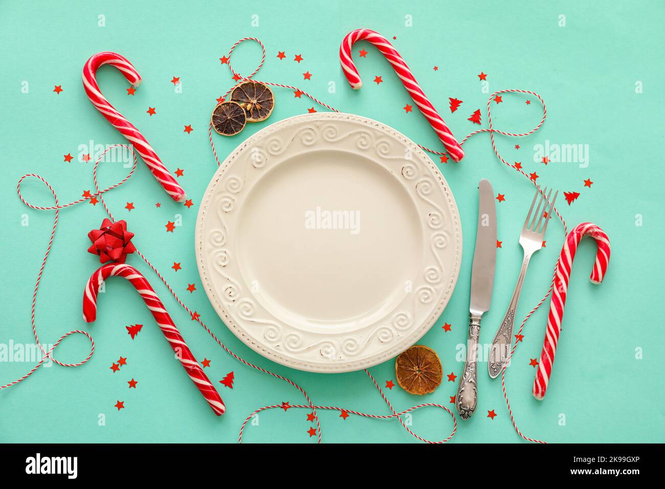 Christmas table setting with candy canes on color background Stock ...