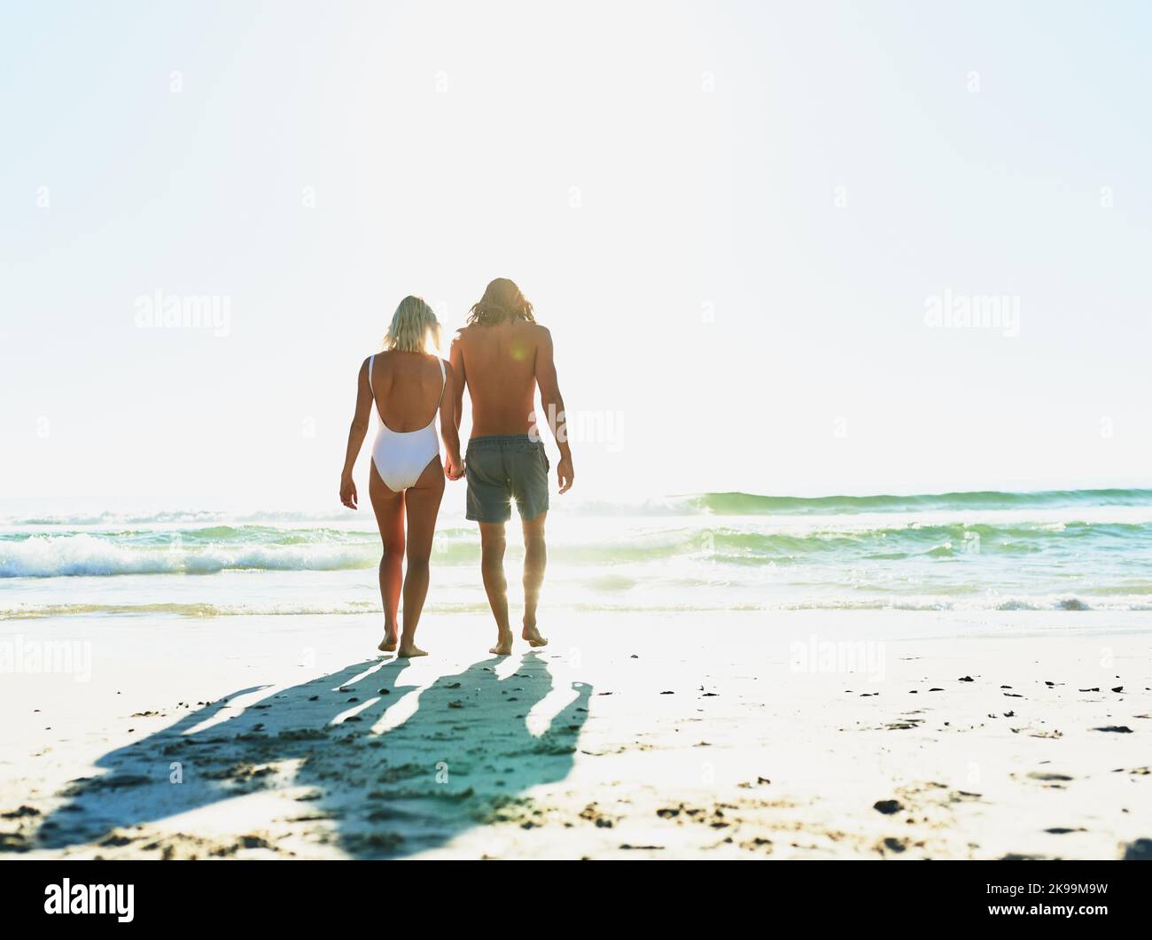 Go out and find some beauty in the world. Rearview shot of a young couple enjoying some quality time together at the beach. Stock Photo
