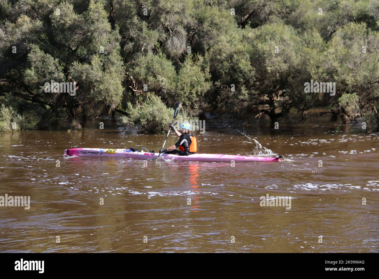 A protected competitor driving a boat on a river Stock Photo