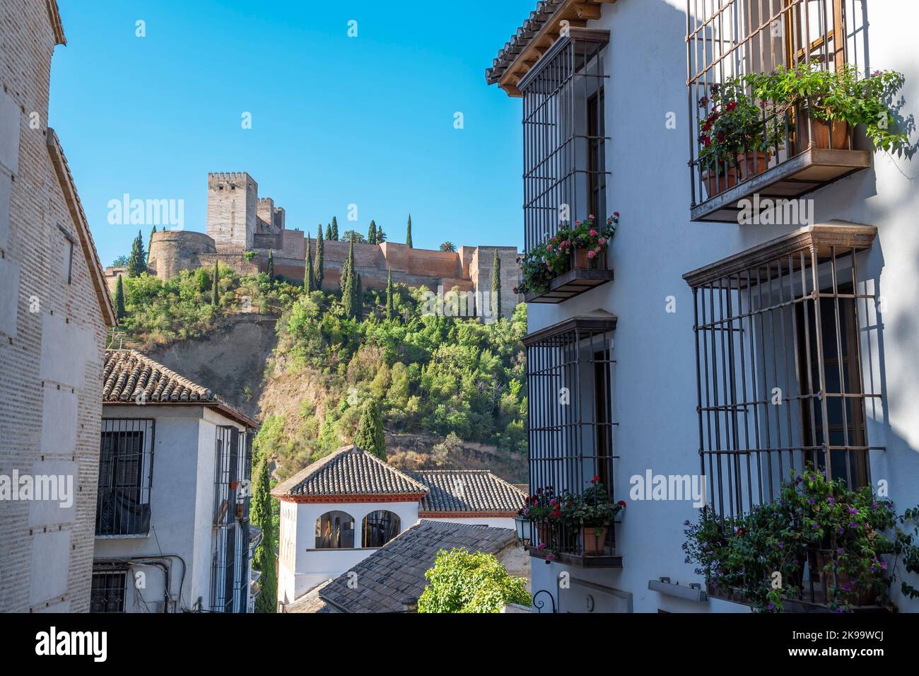 Vista alejada de la Alhambra desde una calle de tradicionales casas blancas de la ciudad de Granada, EspaÃ±a Stock Photo