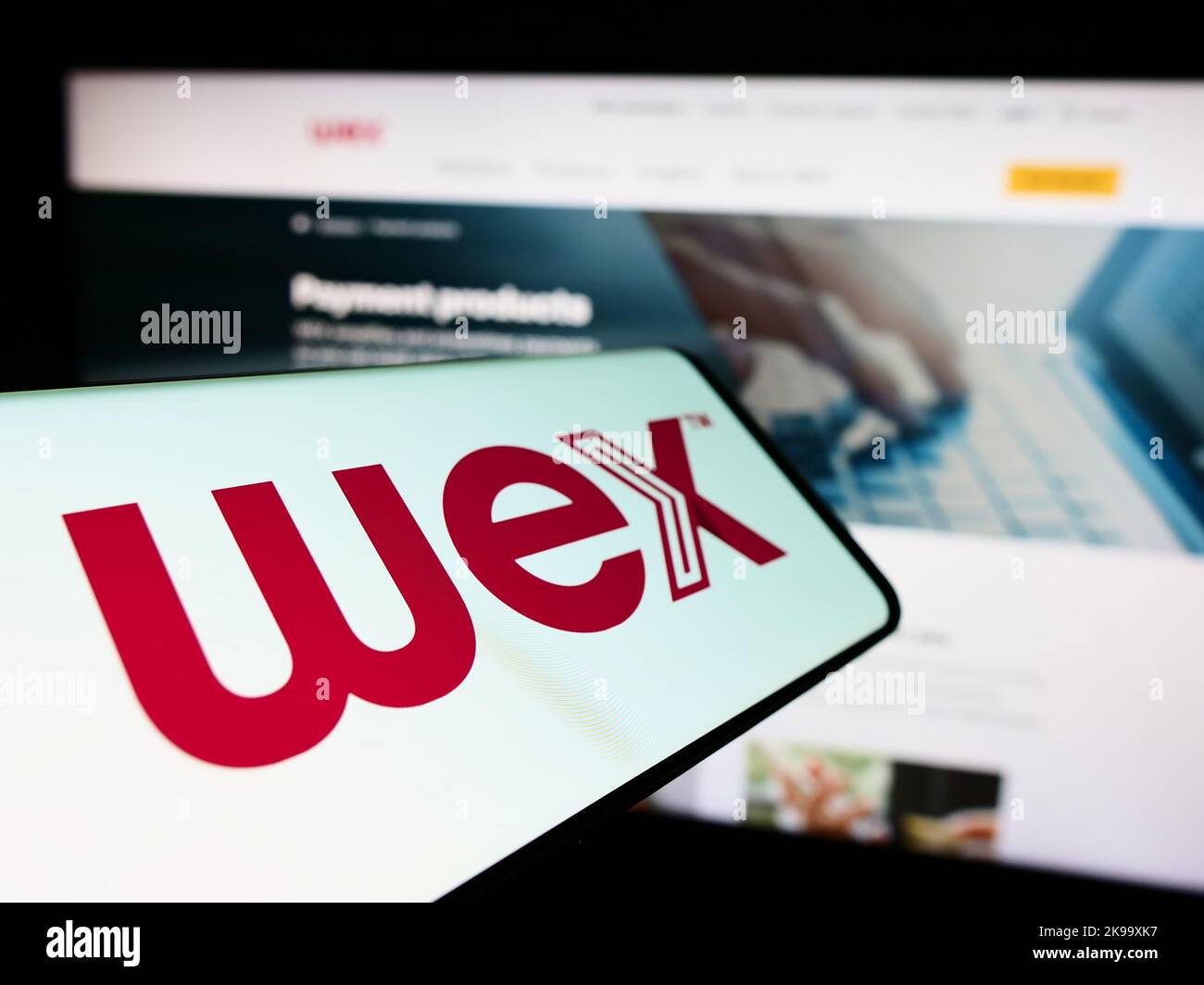 Smartphone with logo of American payment processing company WEX Inc. on screen in front of business website. Focus on center of phone display. Stock Photo