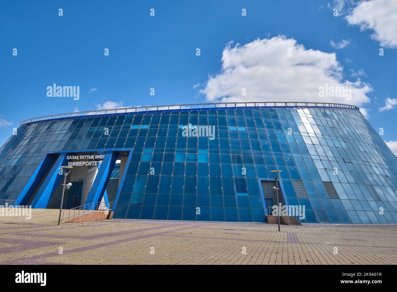 A view of the curved, blue, glass, dog bowl shaped Shabyt Palace of