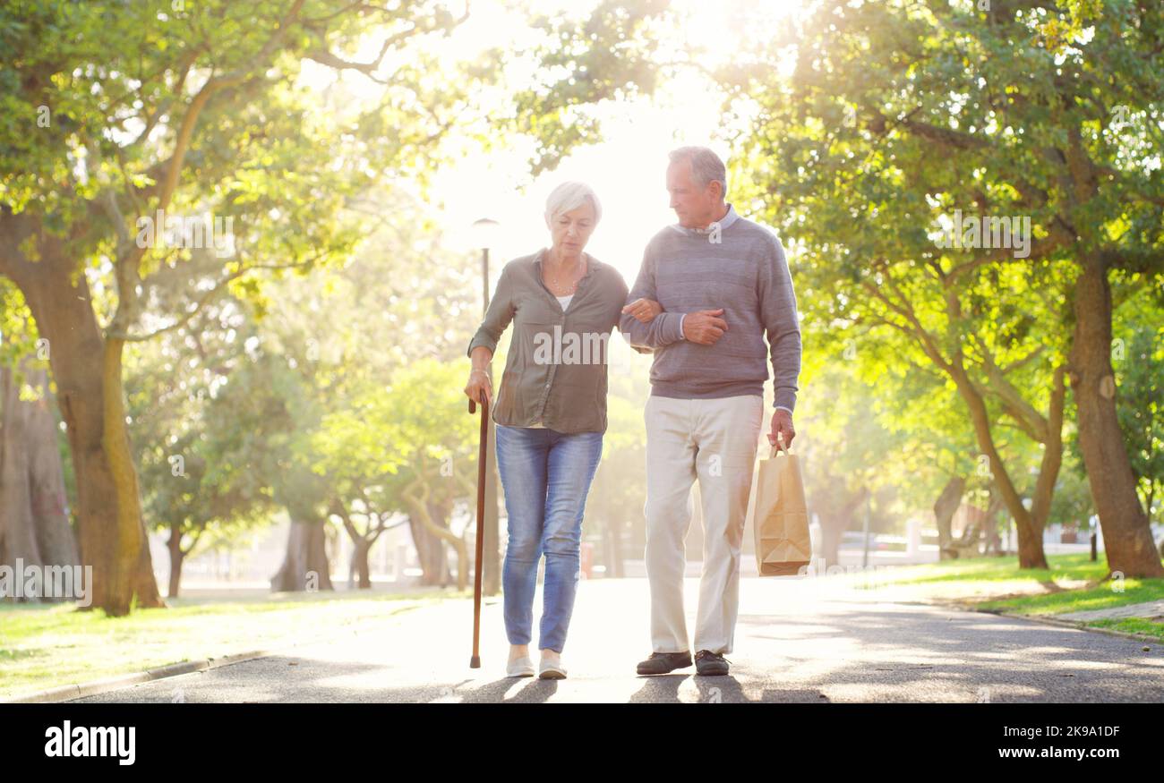 Hell never break his vow to her. Full length shot of an affectionate senior man assisting his wife while walking at the park. Stock Photo