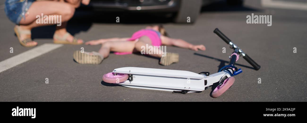 Girl with scooter hit on road by car, eyewitness worry for child, road accident Stock Photo