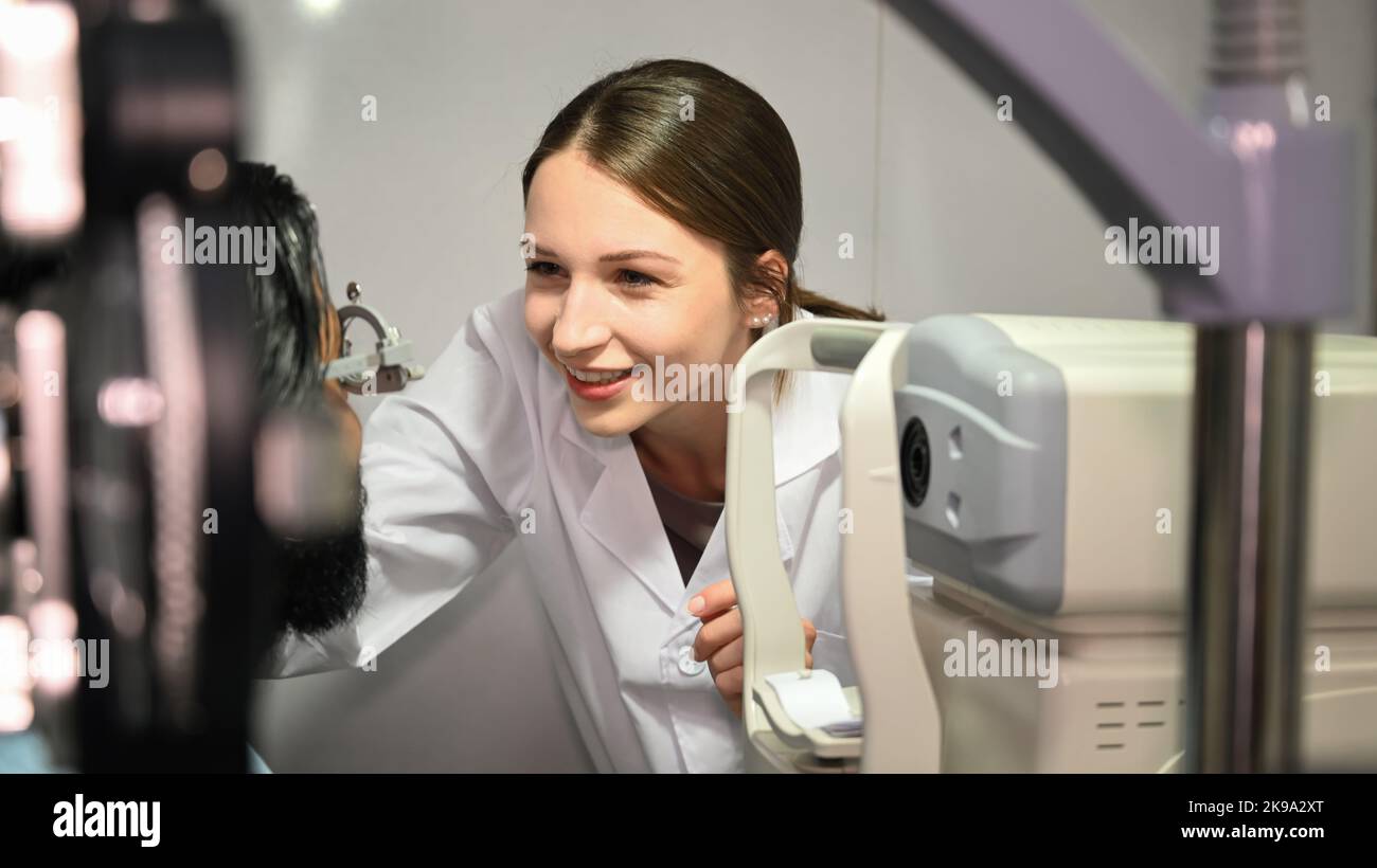 Beautiful female ophthalmologist examining man with optometrist trial frame. Eye health check