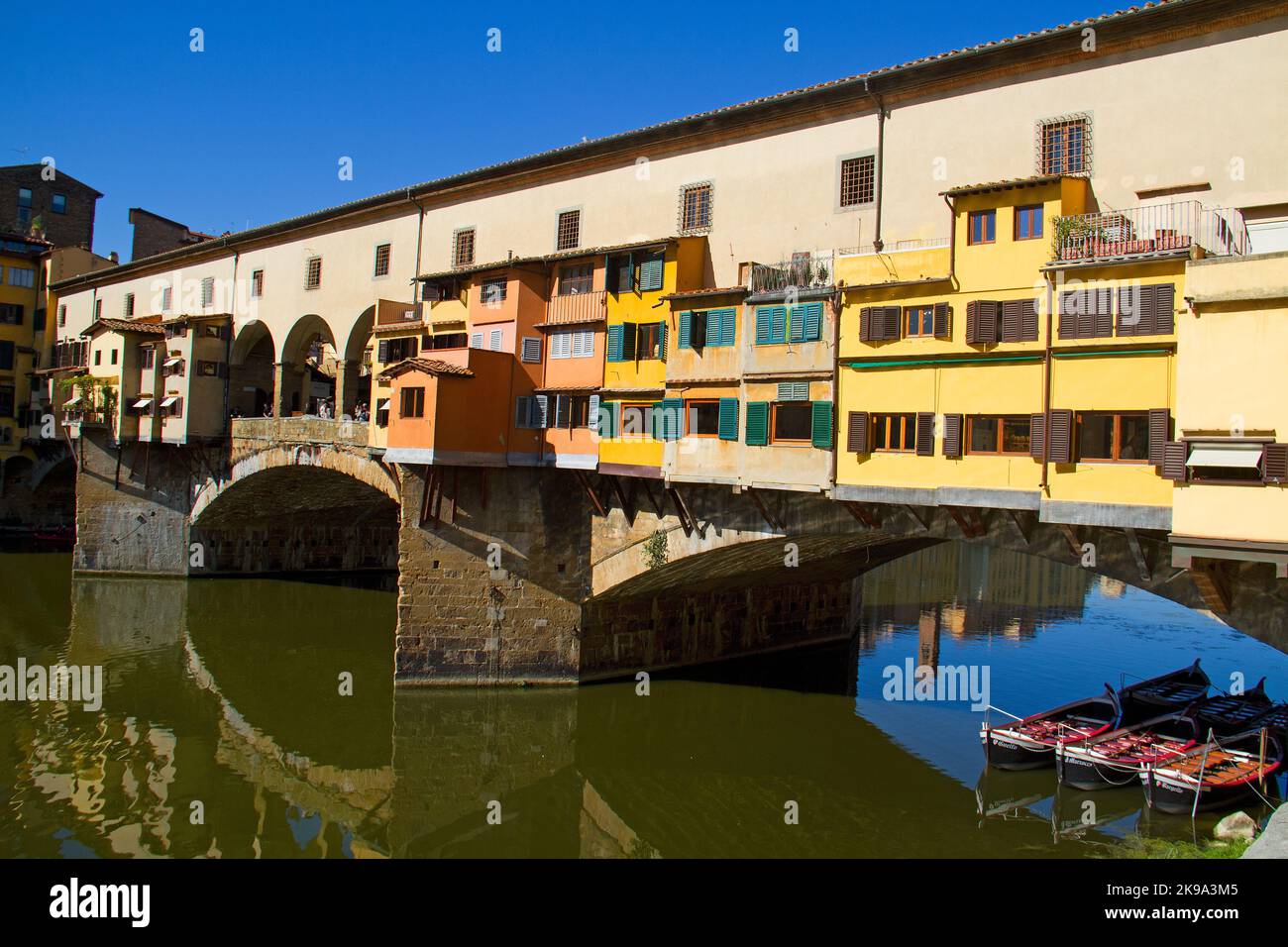 Arch bridge, the Ponte Vecchio in Florence, houses reflected in flowing