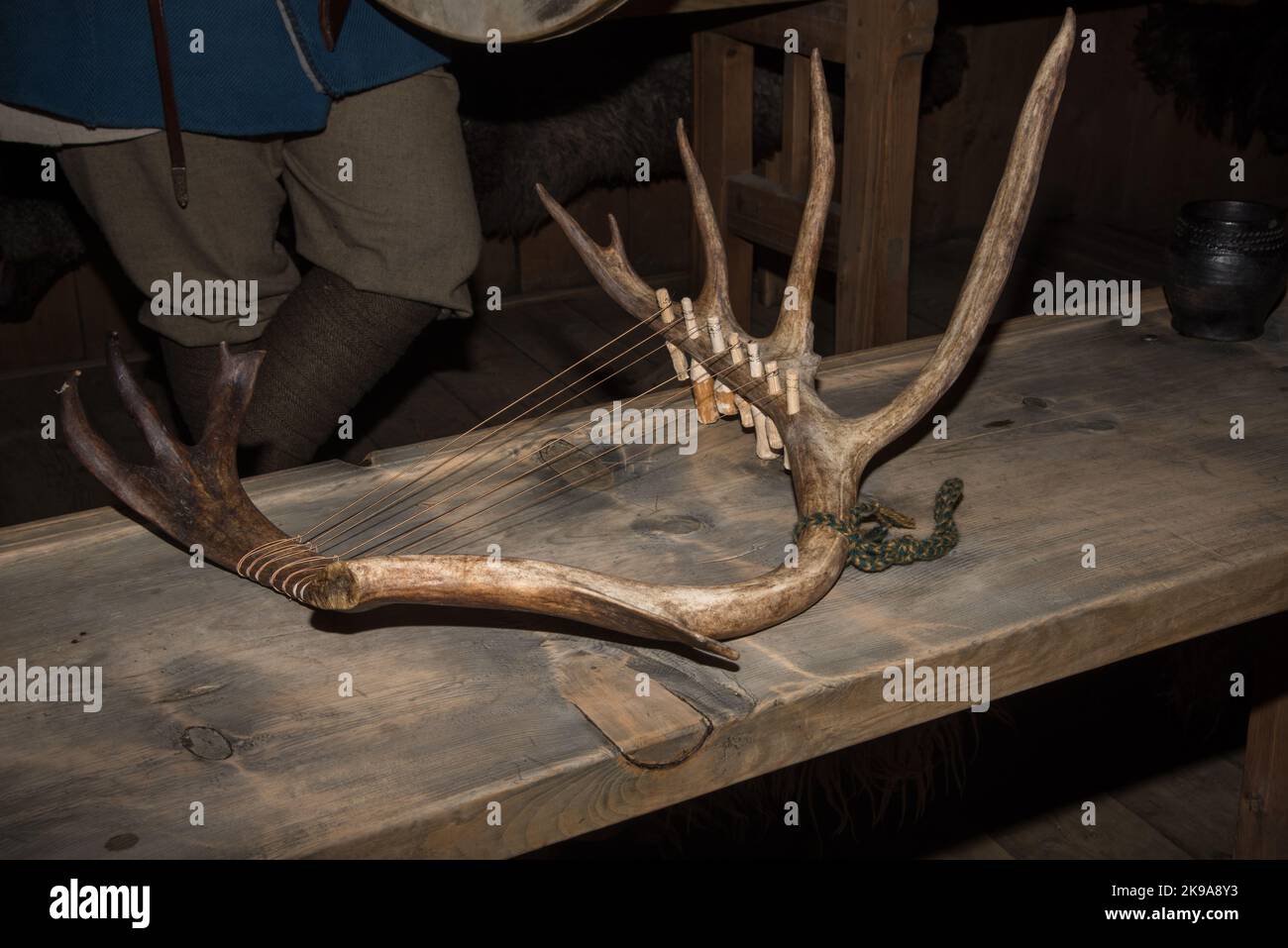Viking actress playing a harp like string instrument in a Viking