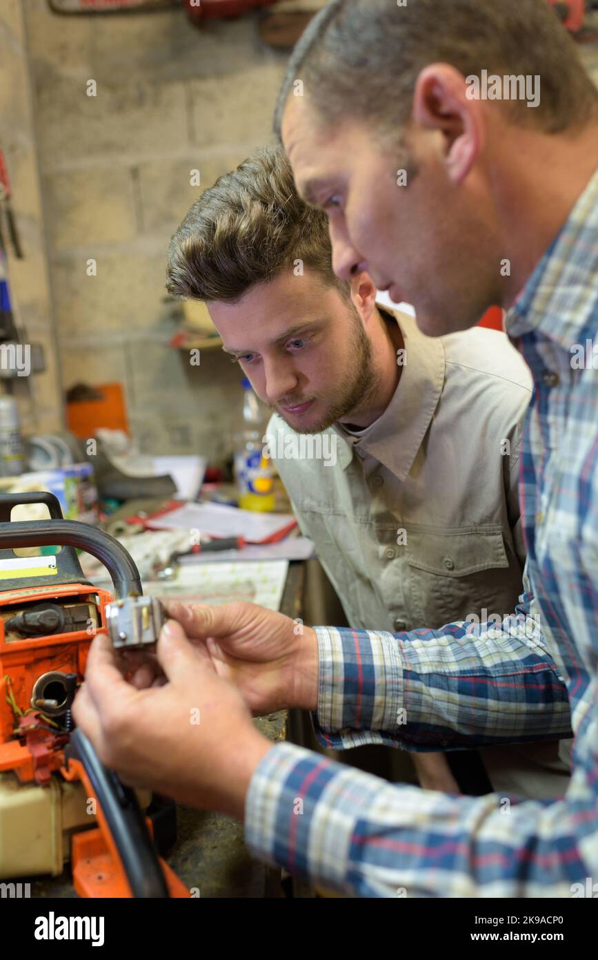 mechanics at repair shop working on a car engine Stock Photo - Alamy