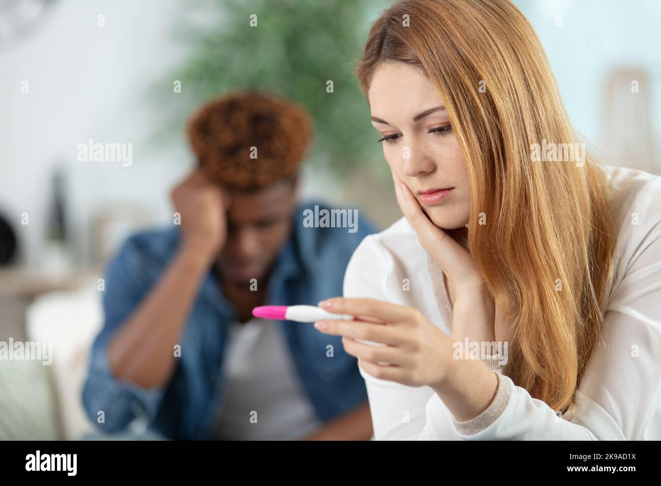 young woman looking at a home pregnancy test kit Stock Photo