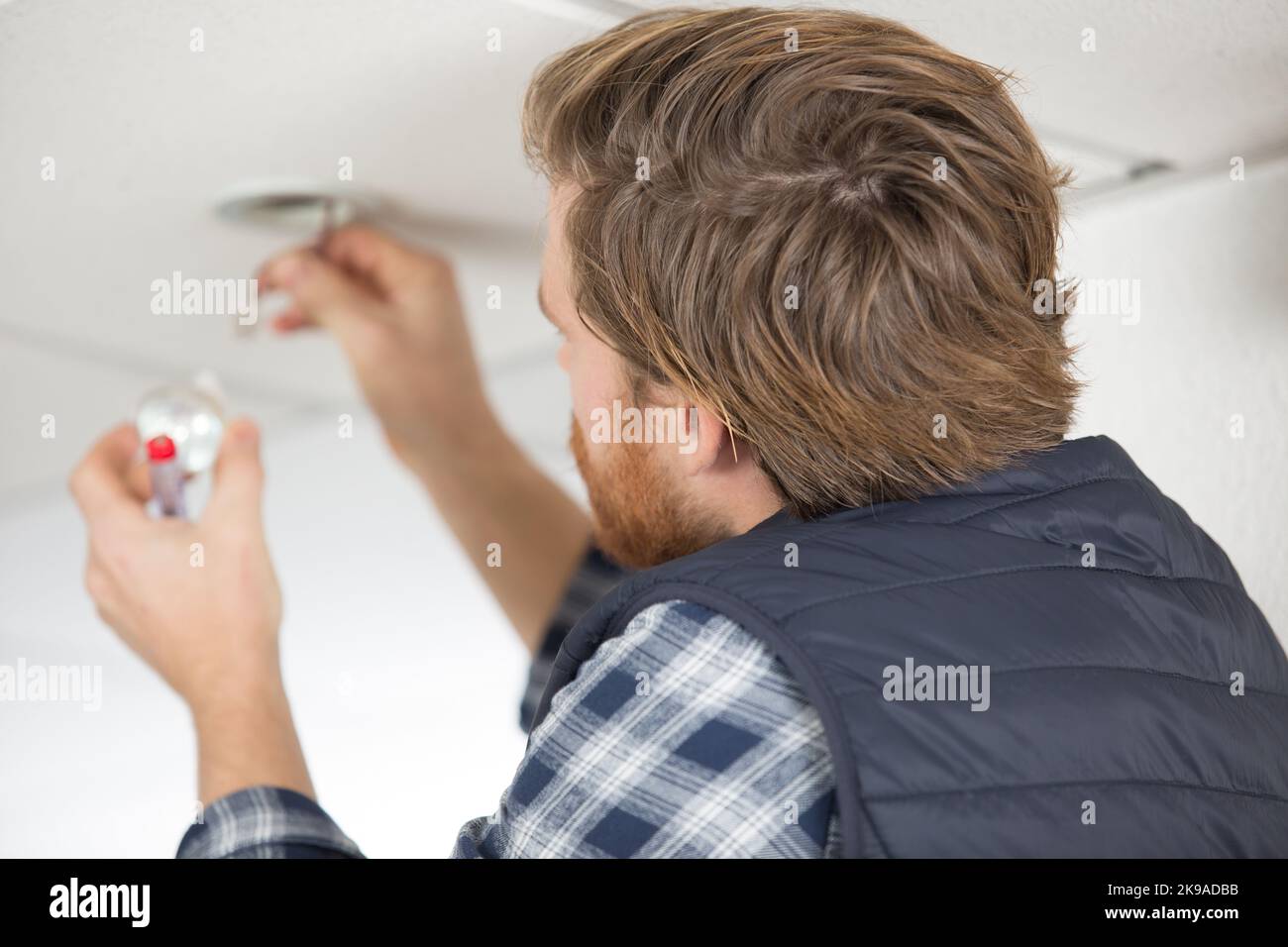 electrician replacing spotlight bulb in the ceiling Stock Photo - Alamy