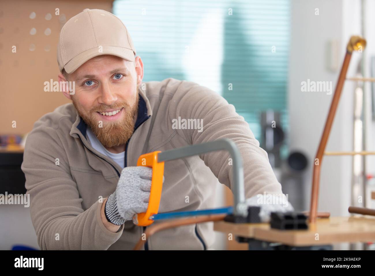 tradesman cutting copper pipe with hacksaw Stock Photo Alamy
