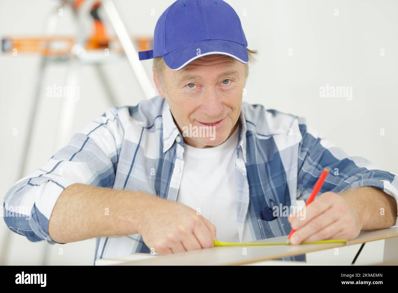senior carpenter using tape measure Stock Photo