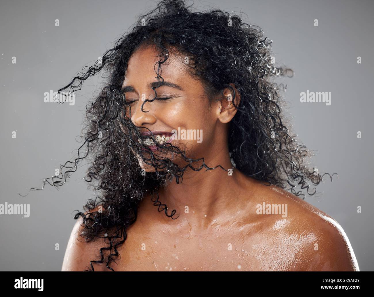 Healthy, wet hair and skincare beauty of a black woman with cosmetics product mockup to hydrate, nourish and moisturize African hair. Clean skin Stock Photo
