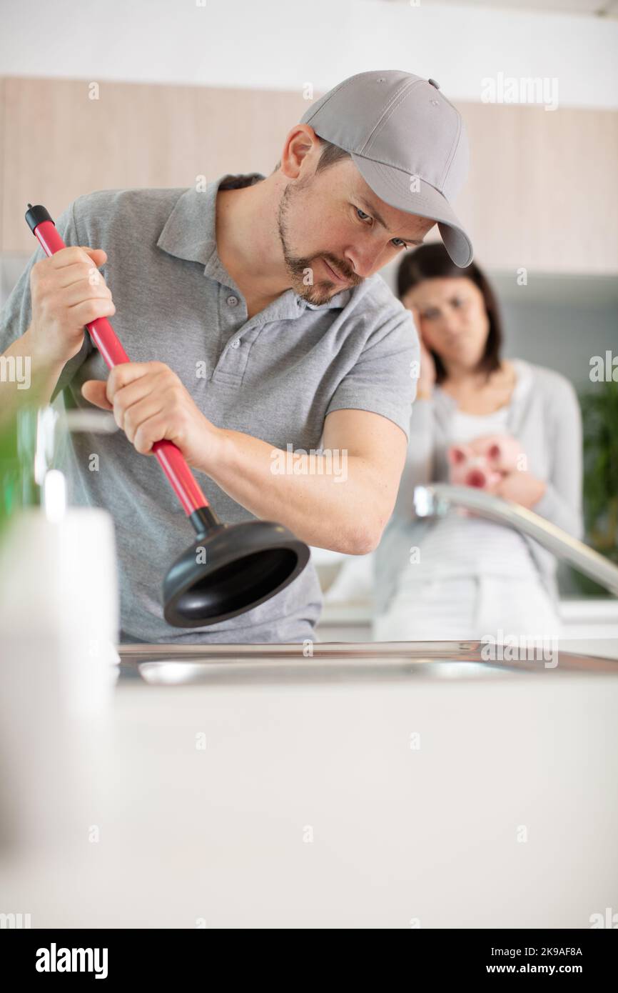 male plumber using plunger in kitchen sink Stock Photo Alamy