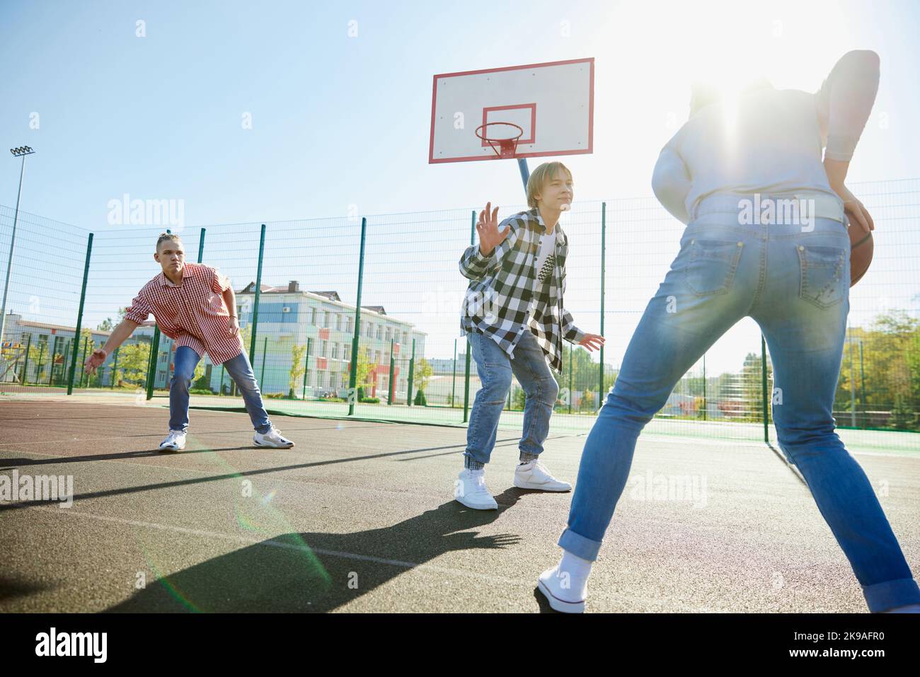 Group of teens, students playing street basketball at basketball court