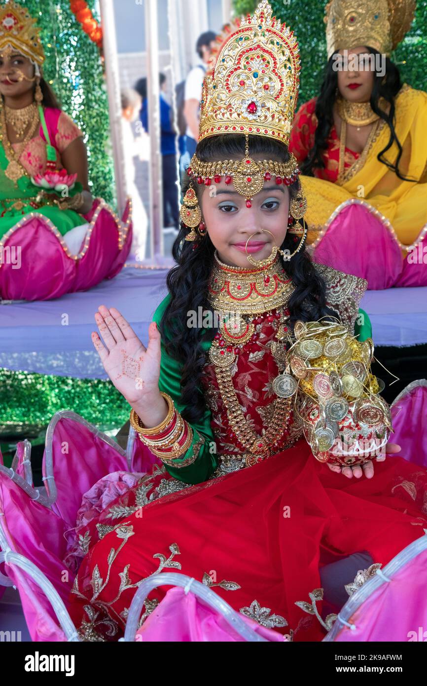 At the 2022 Diwali celebration a very cute preteen poses as Lakshmi while sitting in a giant lotus flower. On Liberty Ave in Richmond Hill, New York Stock Photo