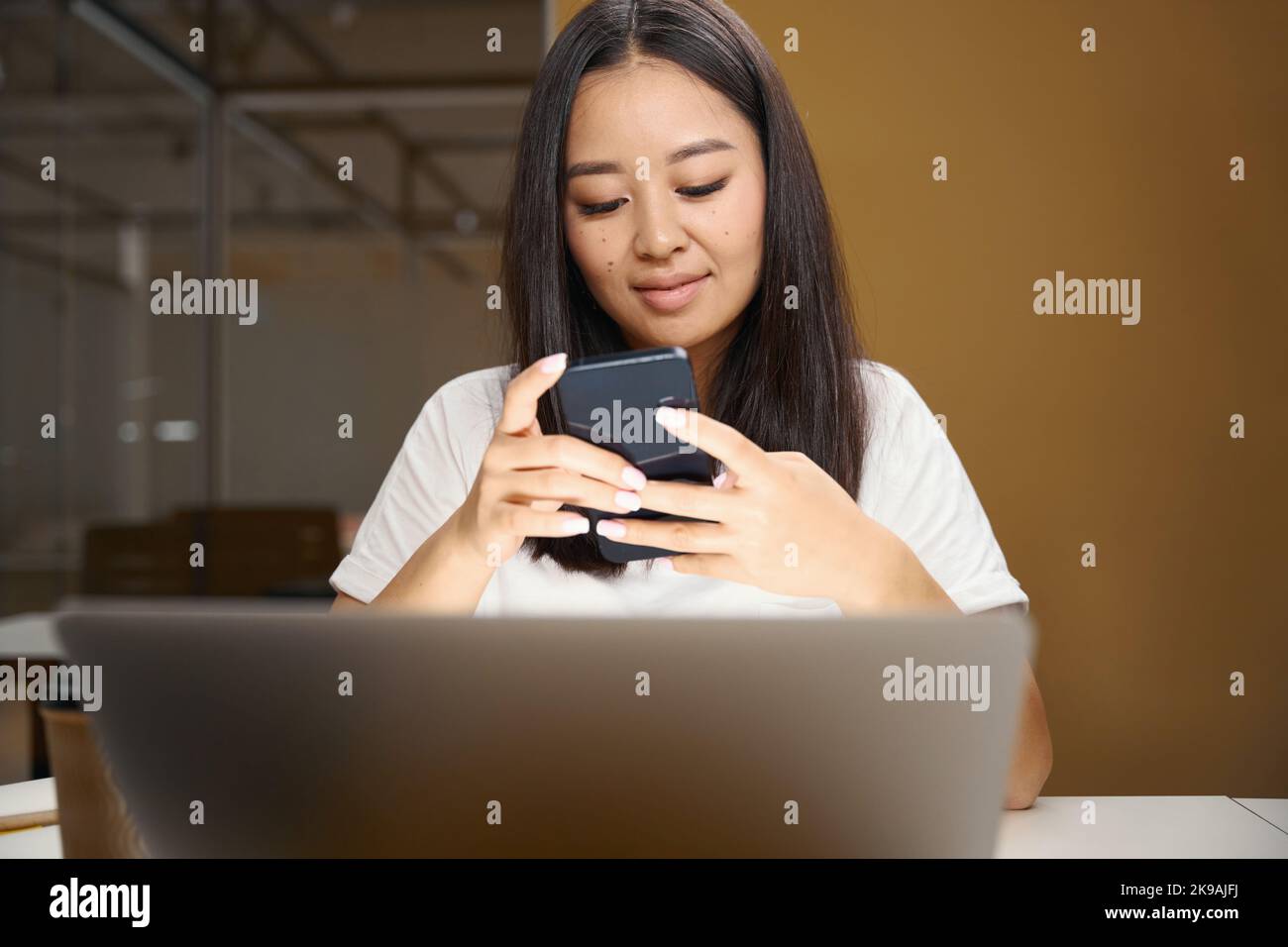Asian entrepreneur with mobile phone is reading email in conference room Stock Photo