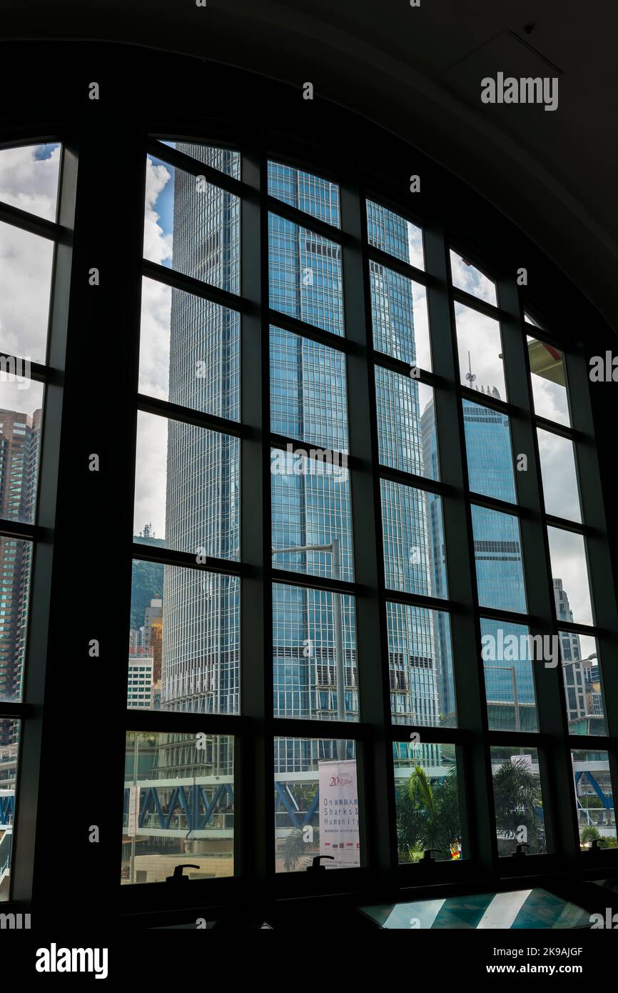 1ifc, 2ifc, and the Central Elevated Walkway framed by a window of the Central Ferry Pier Link Building, Hong Kong Island Stock Photo