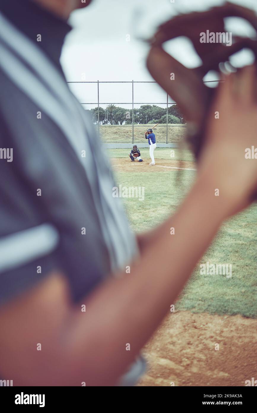 Baseball, sports and fitness with a batter and pitcher on a grass pitch or field during a game or match. Exercising, training and workout with a Stock Photo