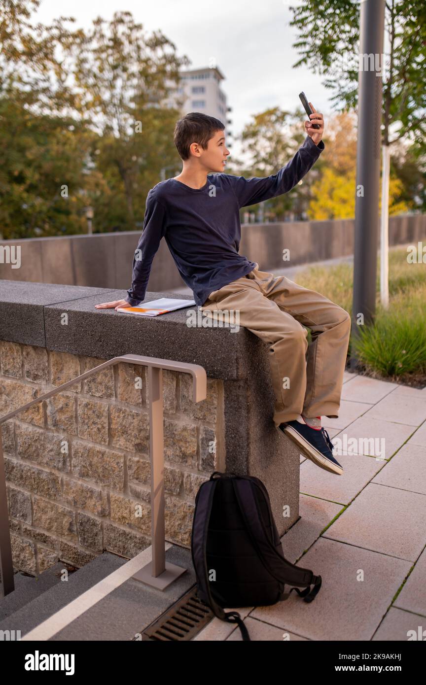 Adolescent taking a selfie on his cellphone Stock Photo