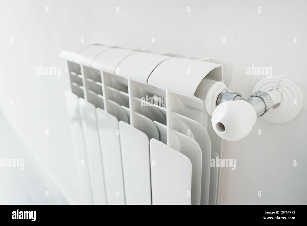 Metal radiator with adjustable valve inside the apartment. Stock Photo