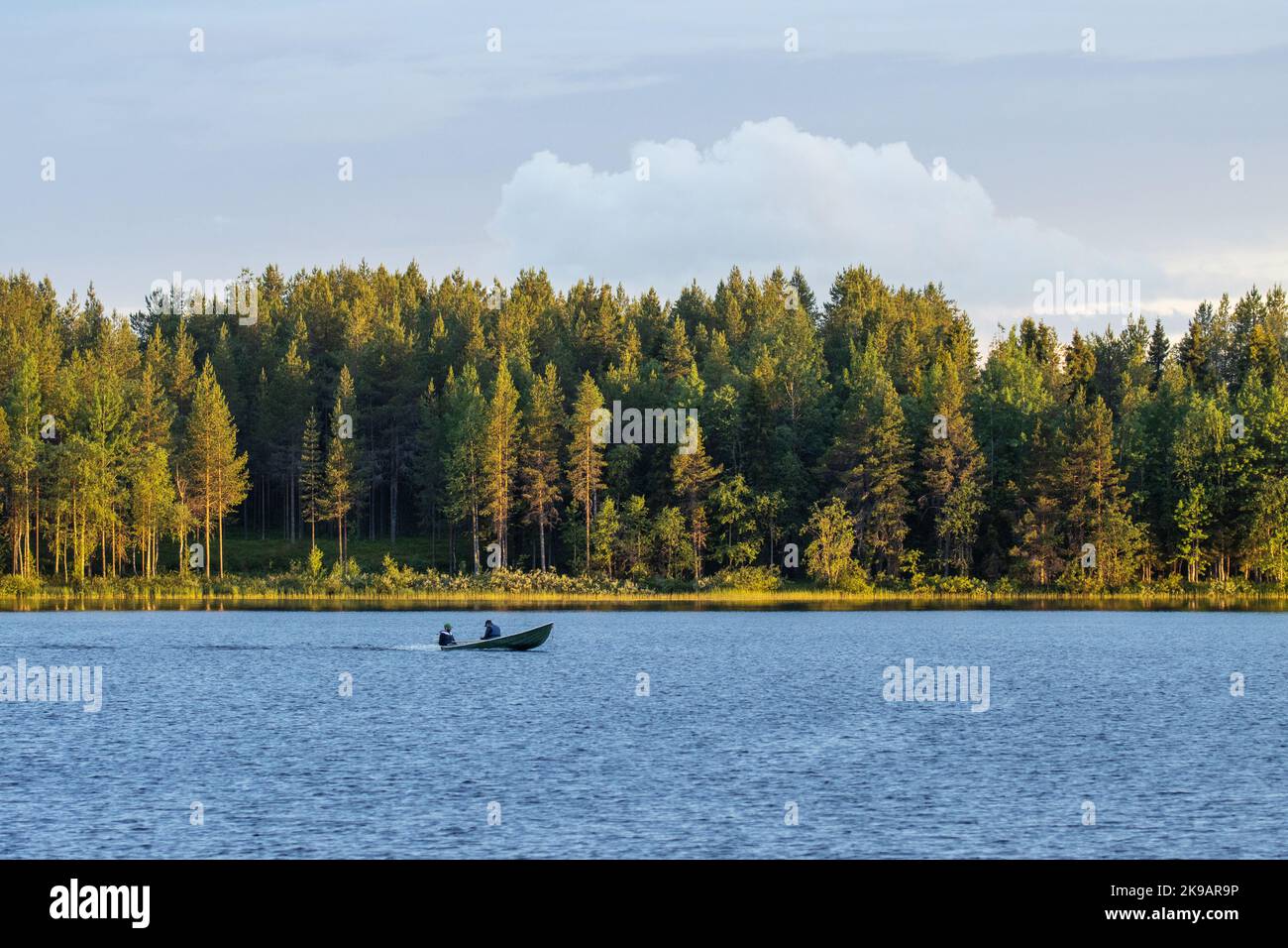 A small motorboat with fishermen on a late summer evening near Kuusamo, Northern Finland Stock Photo