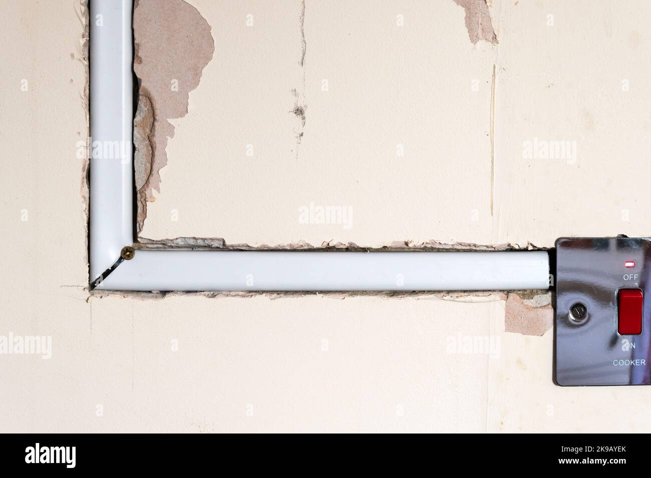 Household wiring chased into wall in conduit from electric cooker switch. Stock Photo