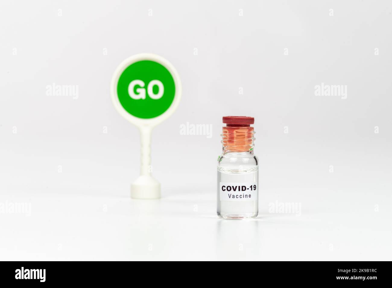 Coronavirus Covid-19 vaccine and message GO on green sign. Stock Photo