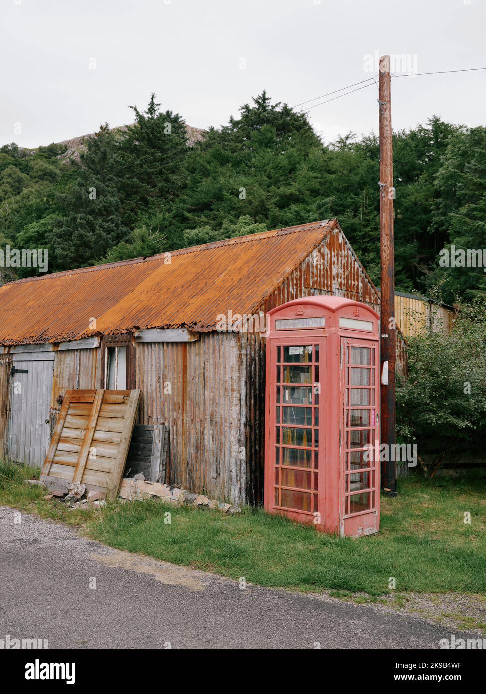A remote faded red village telephone box Lower Diabaig, Achnasheen, Scotland UK Stock Photo
