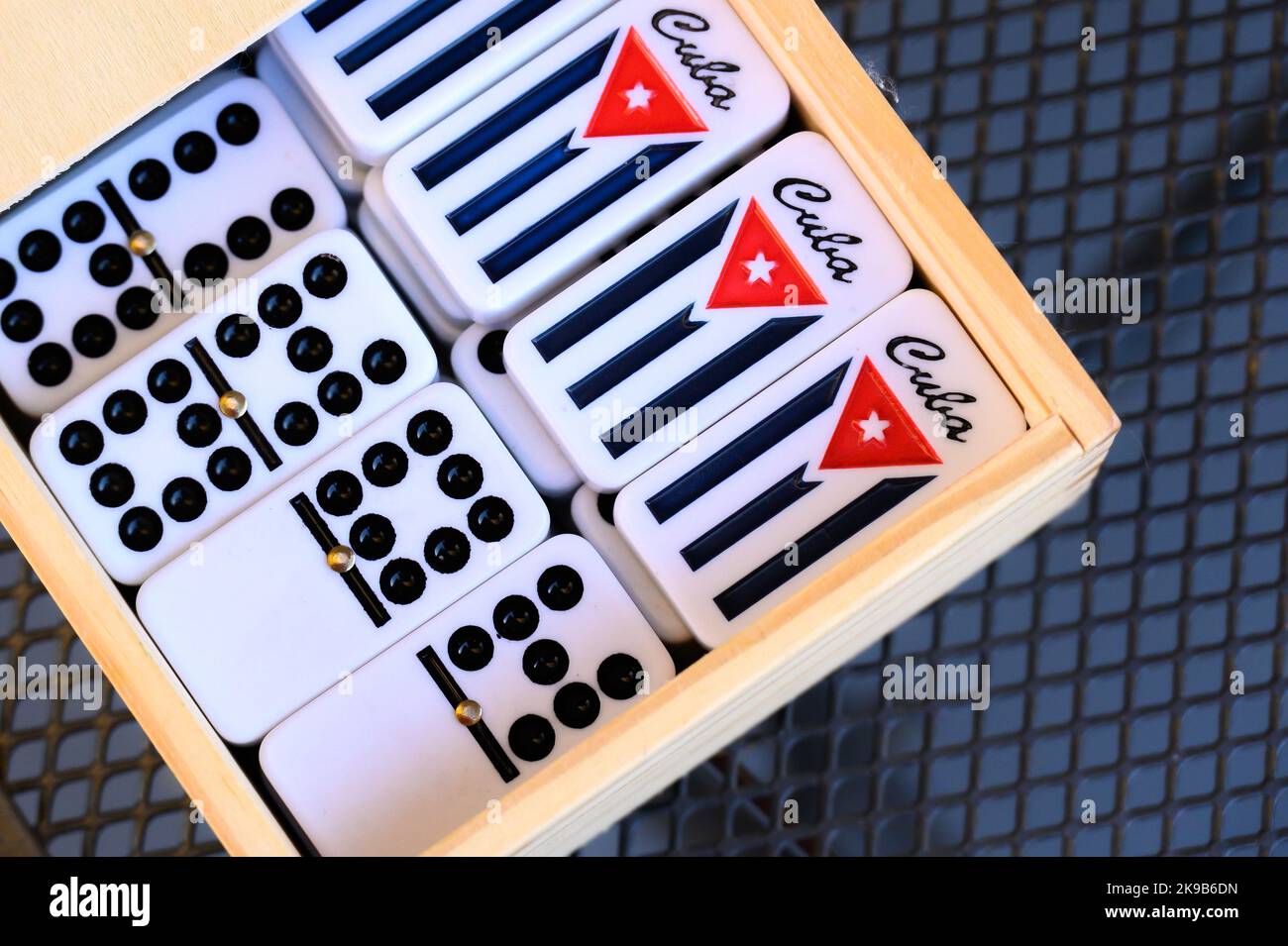 Pieces of dominoes with a Cuban flag decoration in the back Stock Photo