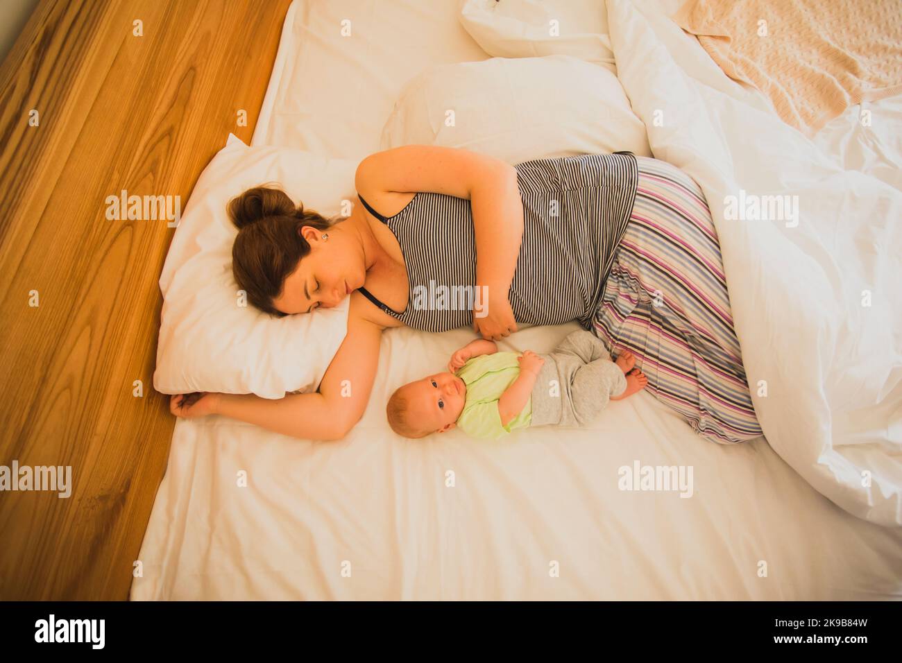 Mother and newborn baby sleep in the bed Stock Photo