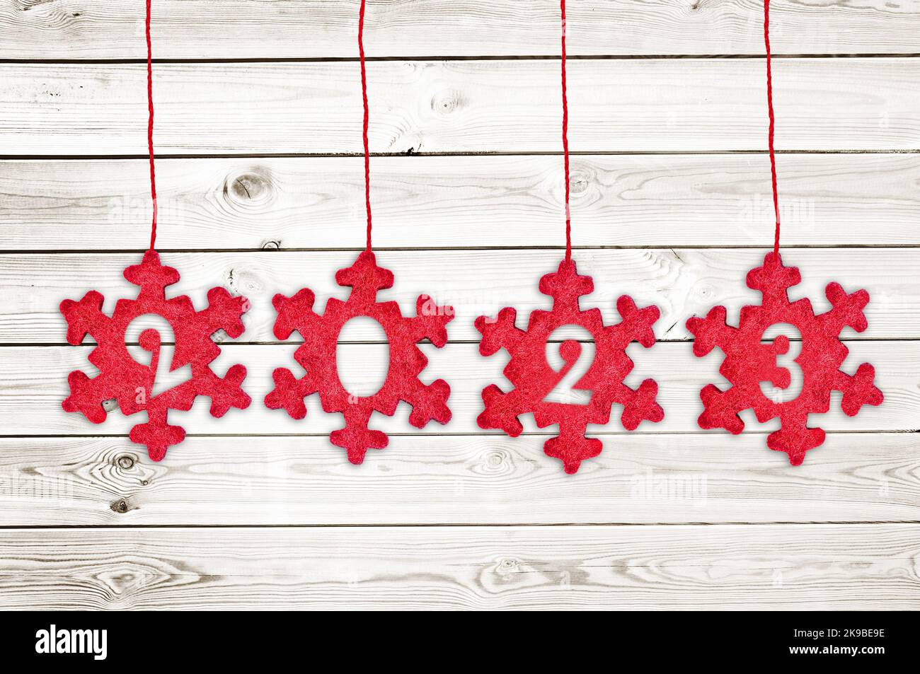 2023 cut in red fabric christmas ornaments hanging on white planks background Stock Photo